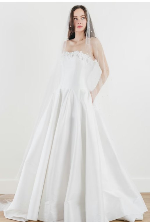 Robe de mariée trapèze à taille basse, fleurs à l'encolure — Nirali par Watters Designs, showroom MADAMOON Paris 10e